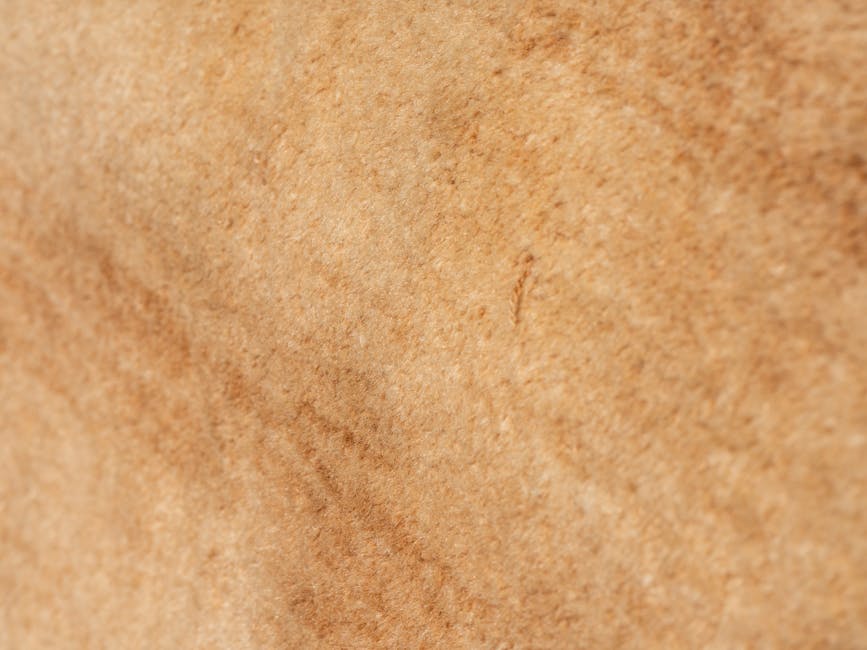 Macro shot showcasing the detailed texture of a beige woven fabric, ideal for backgrounds or design decor.